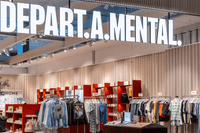 En modern butik med namnet "DEPART.A.MENTAL" i stora vita lysande bokstäver i taket. Inuti syns klädställ med skjortor, klänningar och tröjor i olika färger, samt hyllor med hudvårdsprodukter och accessoarer. Inredningen är ljus med röda hyllmoduler, träd