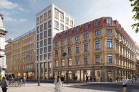 En stadsgata med flera byggnader i klassisk och modern stil. I förgrunden syns människor som promenerar och några sitter vid uteservering. Till höger står en större hörnbyggnad i ljus tegel med rödmålat tak och många fönster i rad. Bredvid finns en högre,