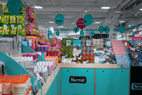Insidan av en Normal-butik fylld med varor på hyllor och displayer, med de karaktäristiska turkosa färgerna och Normal-logotypen synlig.