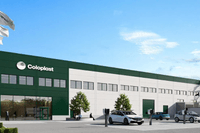Digital rendering (3D-bild) av en stor, modern industrilokal eller ett lagerhus i vitt och mörkgrönt. På fasaden står logotypen "Coloplast". Framför byggnaden finns en parkeringsplats med flera bilar, inklusive laddningsstationer, och flaggor med logotype