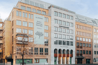 En modern kontorsbyggnad i Göteborg med en ljus fasad, stora fönsterpartier och en stor banner med texten "Kontor i Göteborgs bästa läge?".