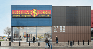 Exteriör av en DollarStore-butik med stora glaspartier vid entrén, tydliga öppettider på fasaden och människor som rör sig utanför.