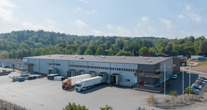 En logistikterminal med flera lastbilar utanför.