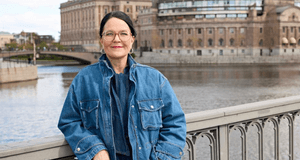 Porträtt av en kvinna i jeansjacka framför Riksdagshuset och Norrström i Stockholm.