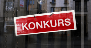 En röd skylt med den vita texten "KONKURS" hängande i ett skyltfönster.