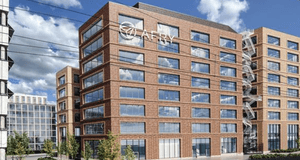 Modern kontorsbyggnad i rödbrunt tegel med stora fönster och åtta våningar. På fasaden syns logotypen "AFRY". En spiralformad utrymningstrappa i metall är placerad på byggnadens högra sida. I förgrunden går ett järnvägsspår, och himlen är blå med moln. An