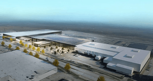 3D-rendering i högt fågelperspektiv av ett storskaligt logistik- och industrikomplex med solceller på taket och parkeringsytor under en klarblå sky