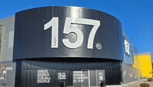 Exteriör av en Lager 157-butik i svarta metallplåtar med stor vit logotyp och information om nyöppning.
