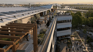 En vidsträckt takterrass på en modern byggnad i flera nivåer, möblerad med soffgrupper och grönska där människor umgås med utsikt över en stad och ett vattenläge i bakgrunden.