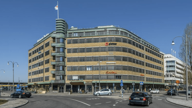 Exteriörbild i grodperspektiv över den funkisinspirerade tegelbyggnaden GP-huset vid Polhemsplatsen i Göteborg under en klarblå sky