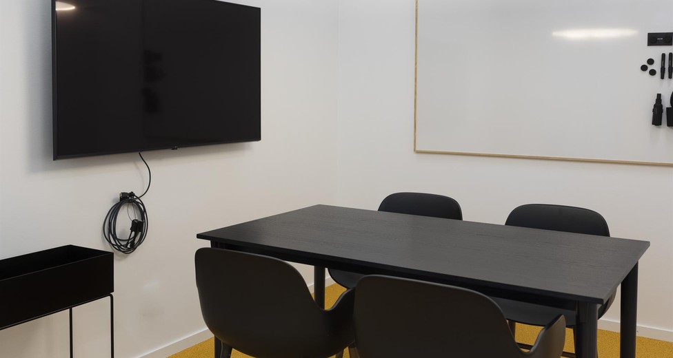 Mötesrum med bord och skärm för effektiva möten.