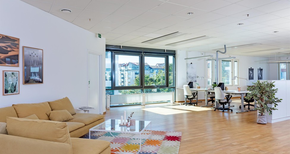 Stor lokal med soffhörna och kontorslandskap.