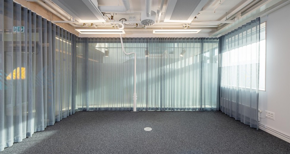 Mötesrum med glasväggar och ljus från intilliggande ytor