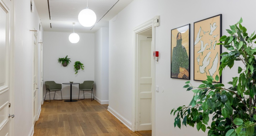 Entré och korridor med konst, växter och bevarade detaljer.