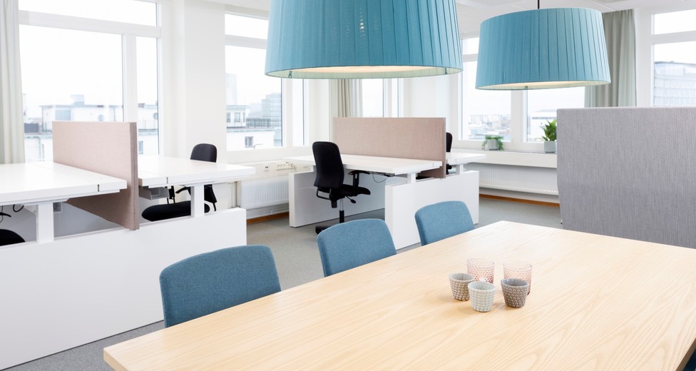 Öppen arbetsyta med möblerad sittgrupp och generöst ljusinsläpp.