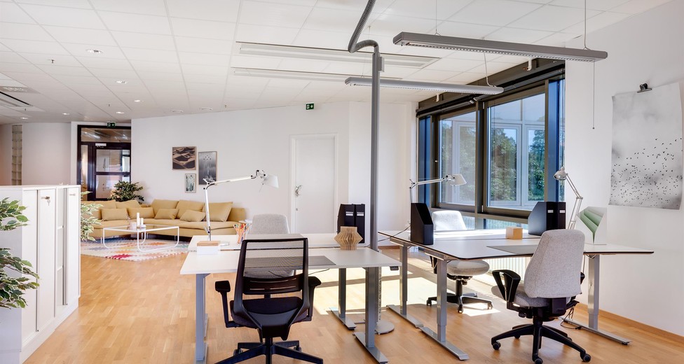 Kontorsrum med arbetsplatser och loungehörna.