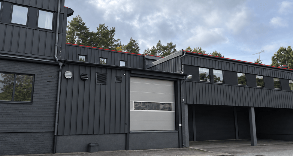 Modern industribyggnad med ljus garageport.png